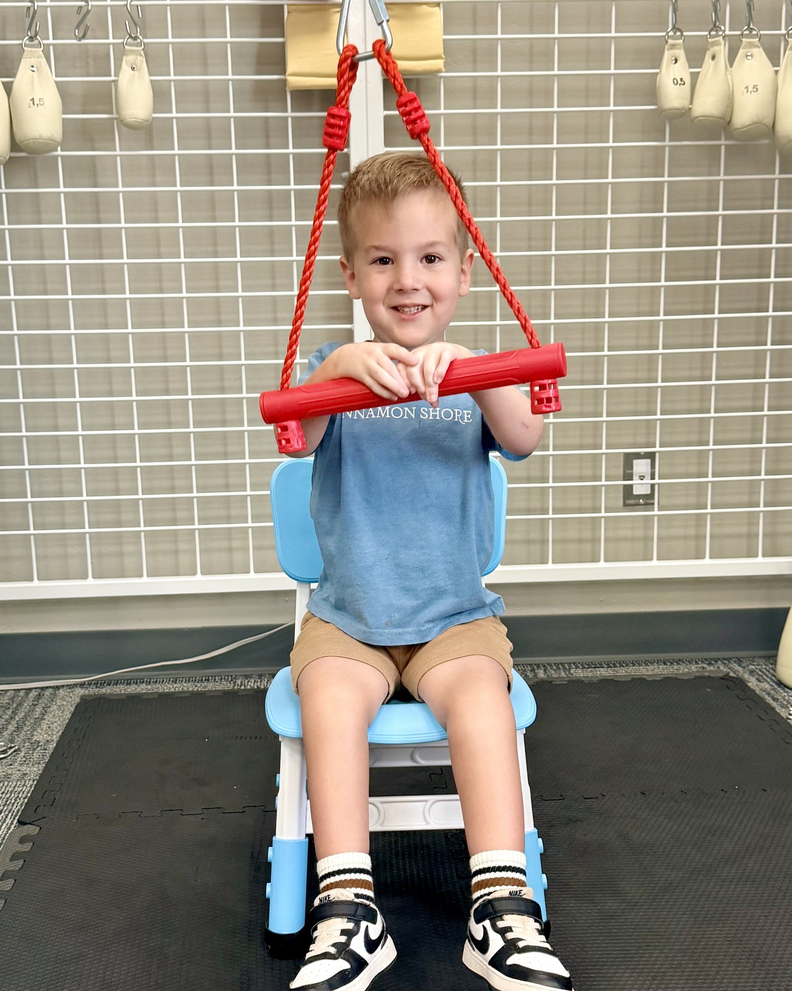 Luke smiling while working in a supportive therapy chair at the clinic.