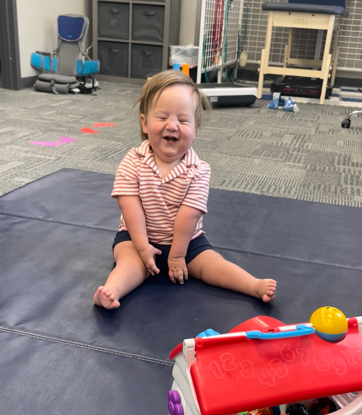 Luke sitting up on his own, smiling.