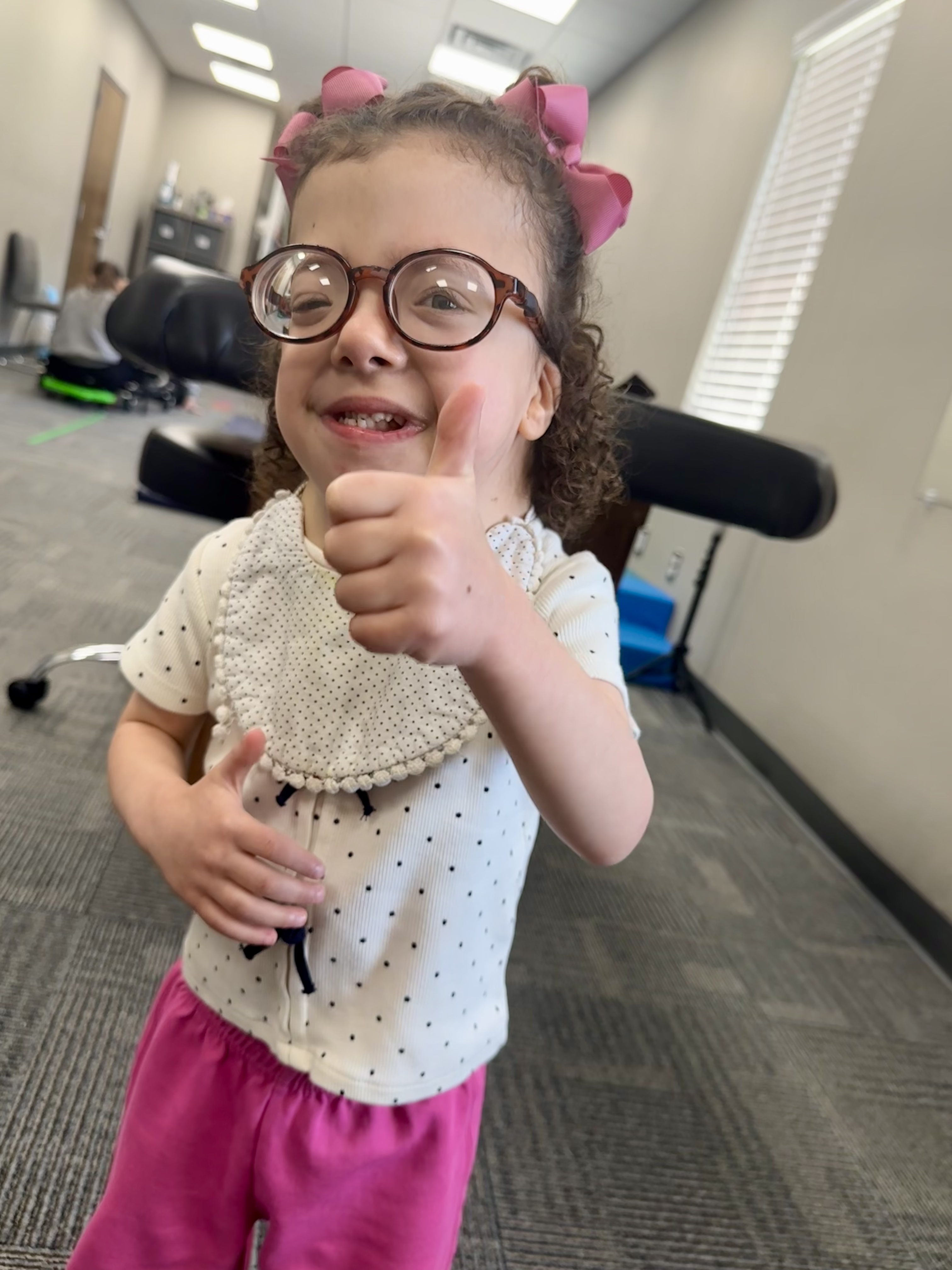 Elton smiling and giving a thumbs up during a therapy session at the clinic.
